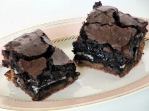 A white plate with two rich slutty brownies.