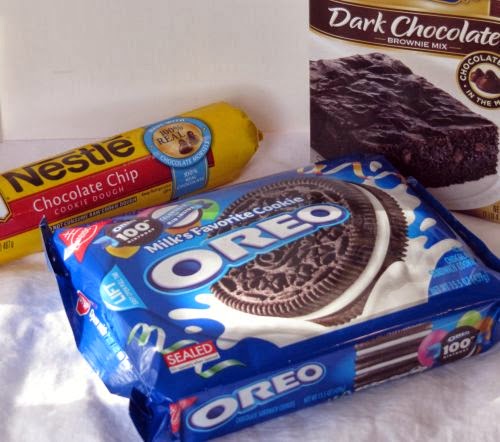 ingredients for slutty brownies recipe consisting of a box jof Oreo cookies, a box fof brownie mix and a roll of chocolate chip cookie dough.