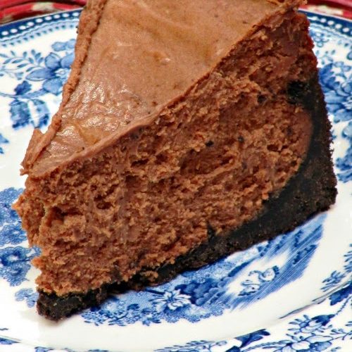 slice of triple chocolate cheesecake on a blue and white plate.