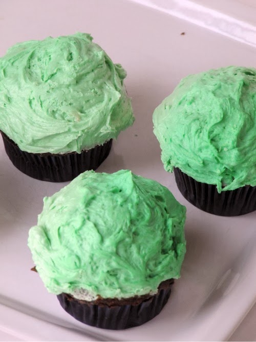 chocolate cupcakes made with guinness topped with green frosting.