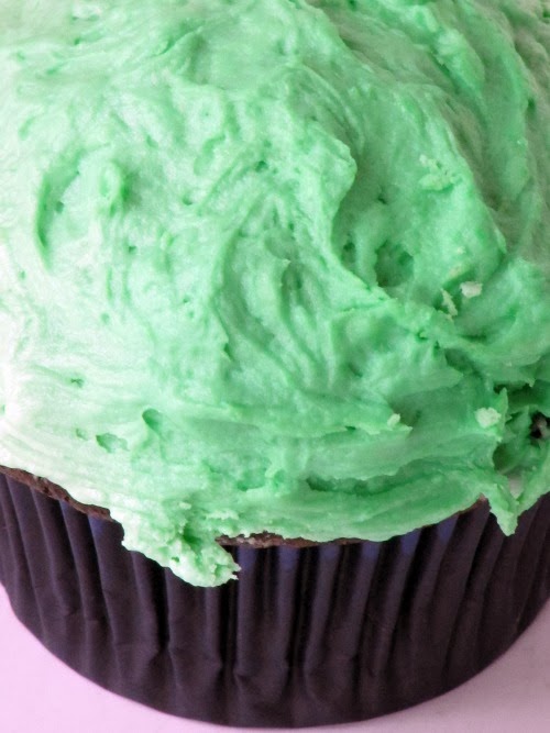 close up view of green frosting on a chocolate guinness cupcake.
