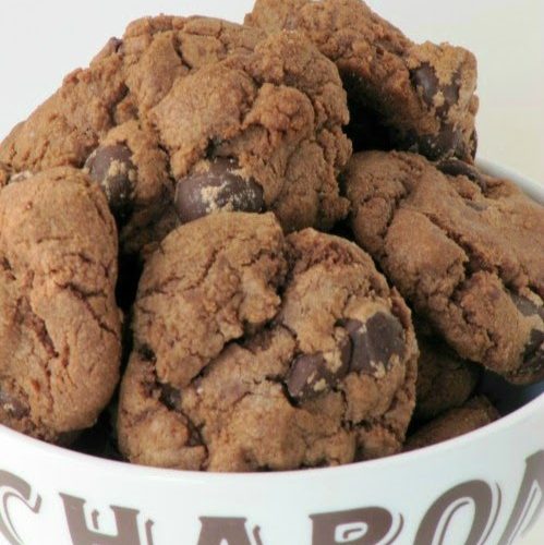 Large pile of double chocolate chip cookies in a white ceramic bowl