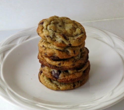 A stack of the best chocolate chip cookies ever on a white platter.