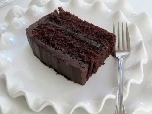slice of wellesley chocolate fudge cake on a white plate with a fork.