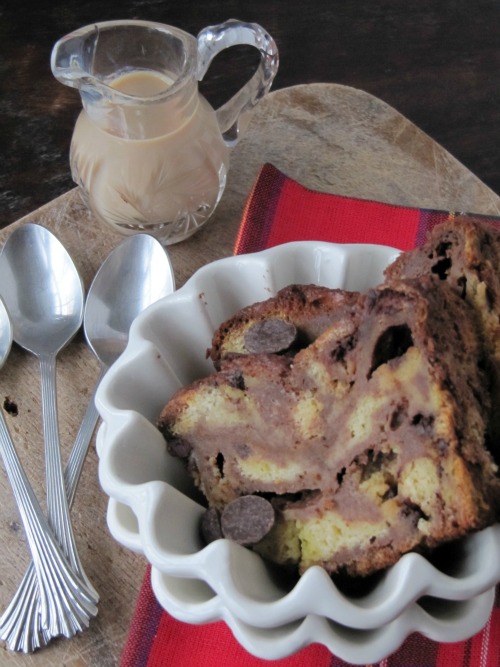 Close-up of a a white fluted bowl holding a large serving of rich buttery Bailey's chocolate brioche bread pudding made with Bailey's Irish Cream.