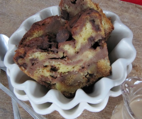 Closeup of a serving of Bailey's chocolate brioche bread pudding made with brioche and flavored with Bailey's Irish Cream in a fluted white bowl.