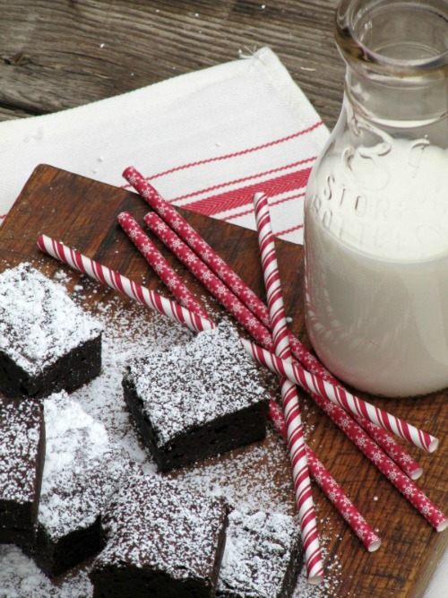 close up view of fudgy chocolate brownies sprinkled with powdered sugar to serve for the holidays.
