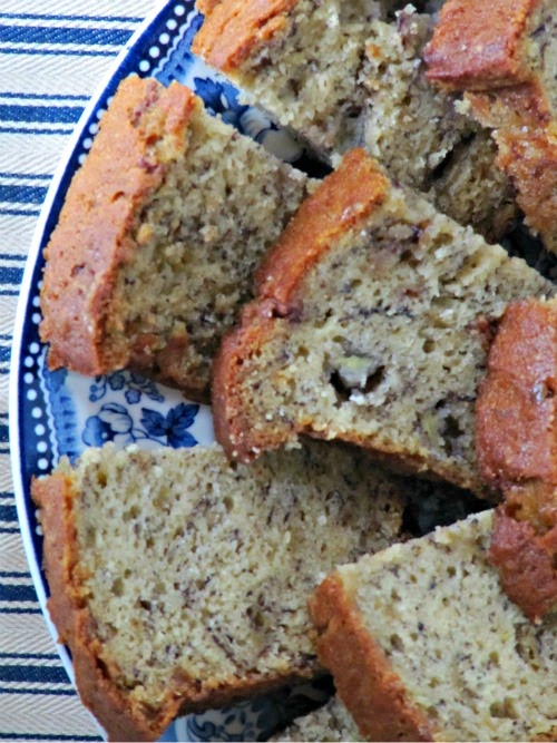 a closeup image of half of a blue and white plate holding slices of plain banana bread that was made along with reese's peanut butter egg banana bread.