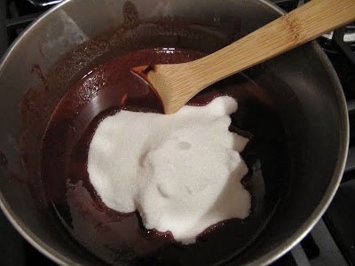 Chocolate and sugar mixture in a stainless mixing bowl with a wooden spoon for making Brownies From Once Upon A Tart.