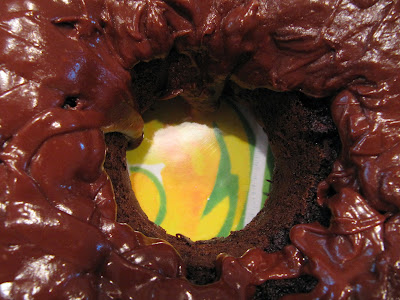 A closeup view of a bundt-style choco-holic cake made with chocolate cake mix, chocolate pudding mix and sour cream and frosted with chocolate glaze frosting.