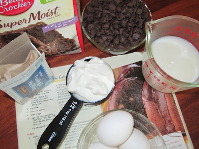 Ingredients for choco-holic cake including chocolate cake mix, chocolate chips, sour cream, milk, eggs and chocolate pudding mix.