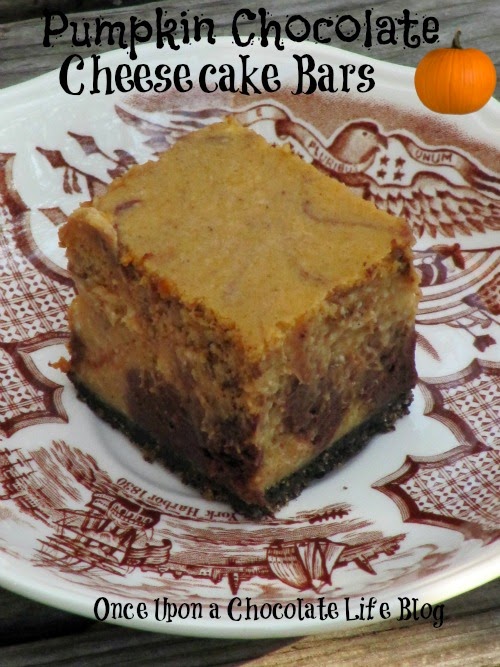 A single chocolate pumpkin cheesecake bar with oreo crust, and a pumpkin spiced cheesecake with a chocolate swirl filling is sitting on a brown and white plate on a brown table.