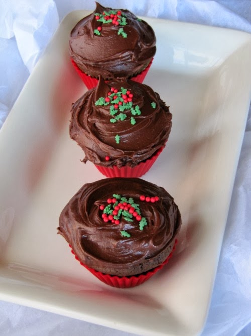 Overhead view of three Chocolate Gingerbread Cupcakes with Hershey's Perfectly Chocolate Frosting sitting on a rectangualr white serving tray.
