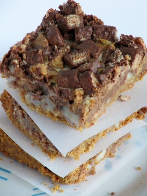 An overhead view of chocolate peanut butter chunk magic bars made with graham crackers, condensed milk, kit-kat candy, and peanut butter cups.