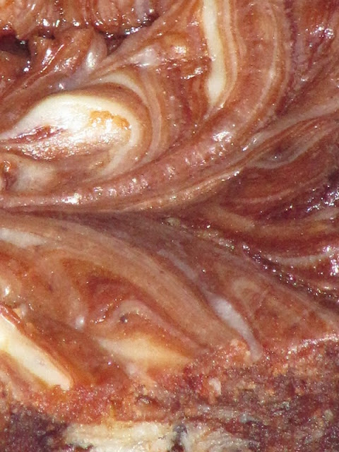 A closeup of  cream cheese brownie recipe chocolate batter showing the cream cheese swirl.
