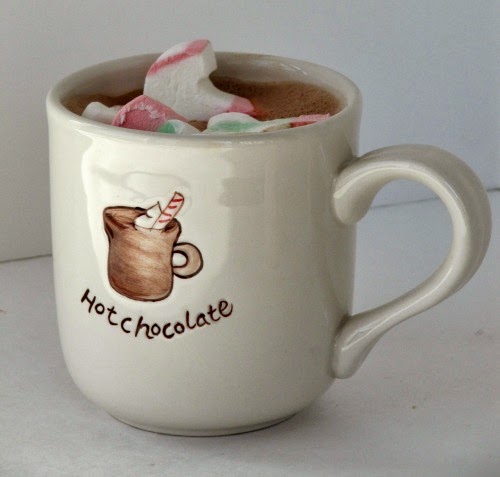 side view of a white hot chocolate mug filled with raspberry liqueur flavored raspberry hot chocolate topped with christmas colored marshmallows.