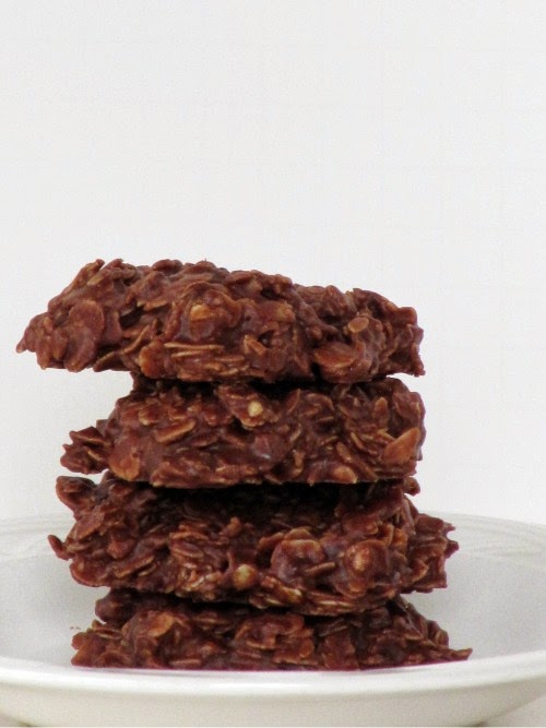 A white plate holds a stack of chocolate peanut butter oatmeal no bake cookies that are made with cocoa powder, peanut butter and oats.