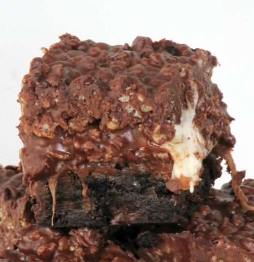 A closeup of a stack of rolo  marshmallow peanut butter brownies made with marshmallow easter egg candy and rolos sitting against a white background.