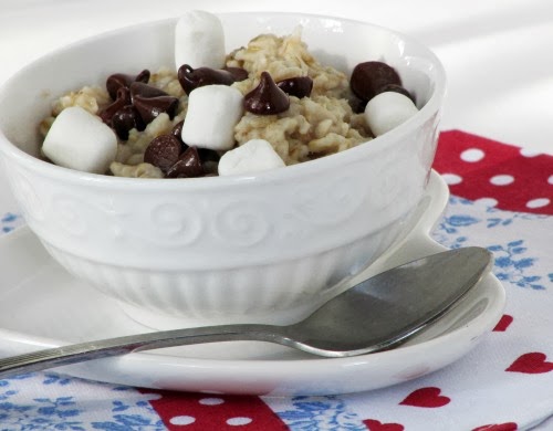 Side view of a white bowl filled with s'mores oatmeal made with oatmeal, dark chocolate chips, marshmallows and graham cracker crumbs.