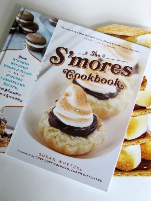 Angled photo of the cover of the S'mores Cookbook by Susan Whtezel that shows s'mores-type desserts on the cover, including Peanut Butter Cup S'Mores.